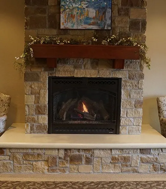 The stone fireplace in the waiting room, with armchairs on either side.