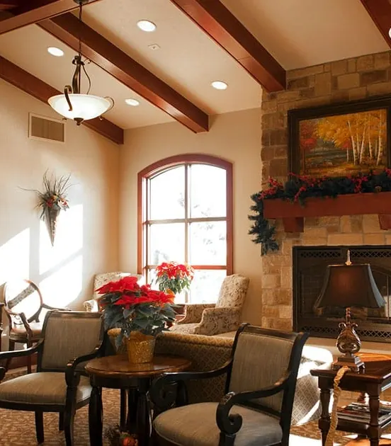 Armchairs, a reading lamp and magazines beside the waiting-room fireplace.